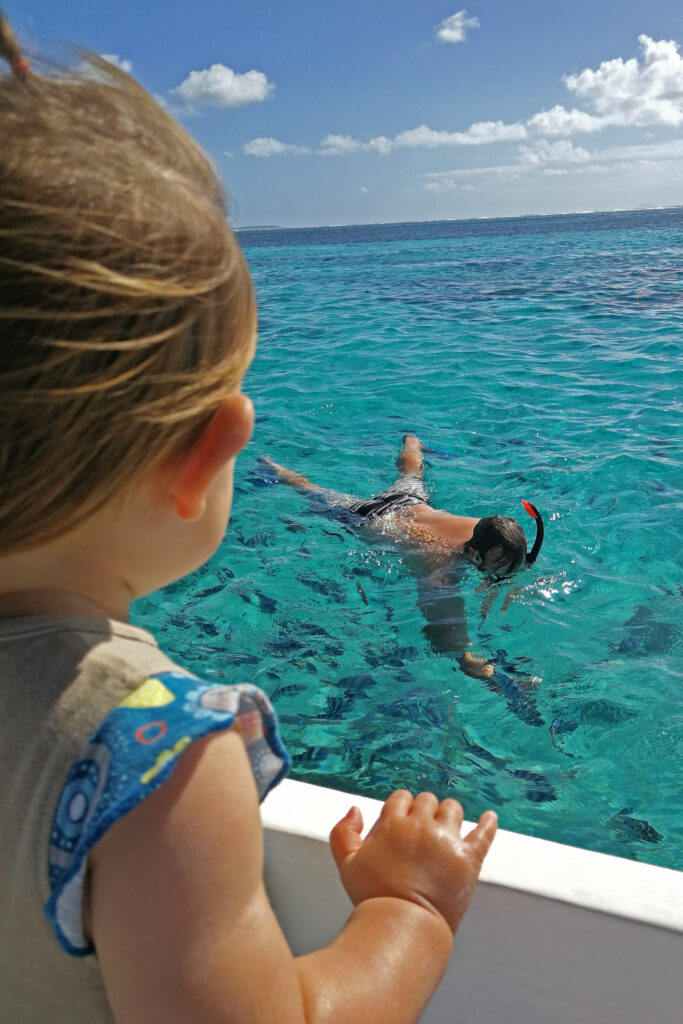 toddler looking at mom swimming in Mauritius