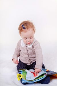 toddler playing with material book