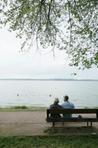 Elderly couple on a bench by a lake