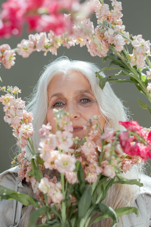 Elderly woman looking through flowers