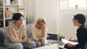 family therapy: a mom and teen sitting on the couch with a therapist