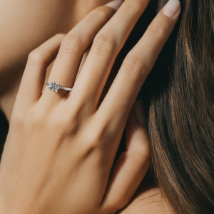 A woman wearing a lab grown ring with her fingers against her hair. Image from Google Gemini