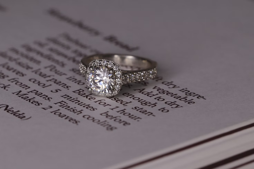 A diamond ring, on a newspaper which has recipe text. 