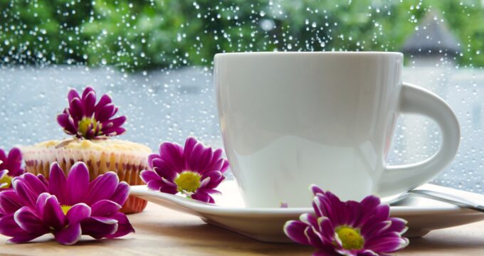 Keep your home clean during the rainy season. A piture of a cup of coffee with flowers next to a rainy window.