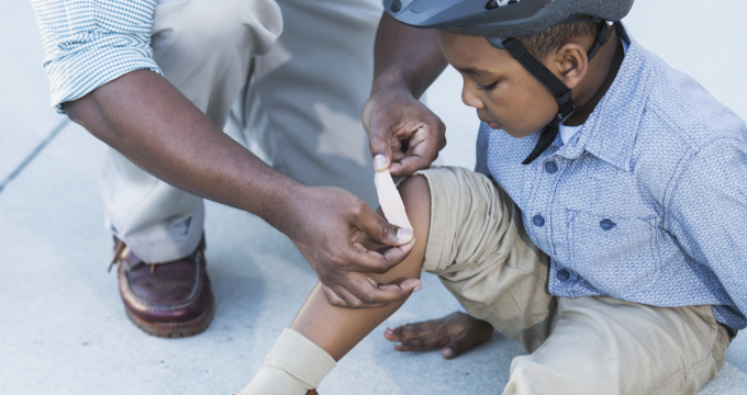 Dad helping his son with a hurt leg. Pain strikes unexpectedly and we need to be prepared.