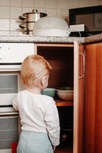 Baby looking in a cupboard