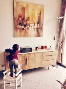 Toddler reaching onto a table.