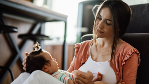 A mom with a crying baby. Babies have their own way of communicationg.