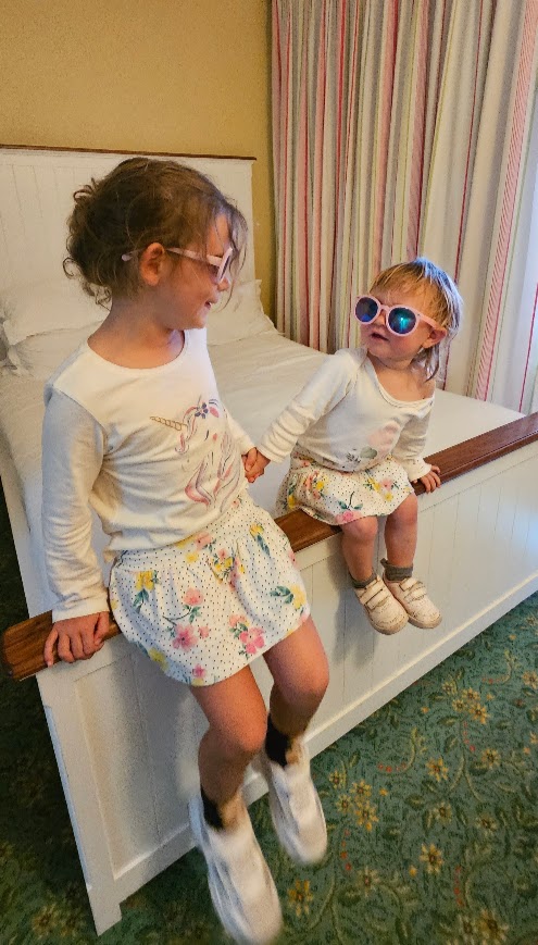 Children sitting on the  bed in sunglasses. 